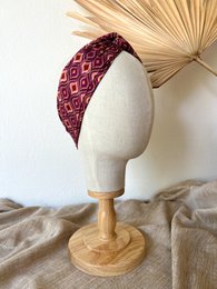 A burgundy and white patterned vintage-style headband with a wide, textured design.