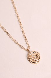  Gold-toned chain necklace with circular pendant featuring intricate floral design.