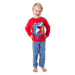 Red long-sleeved pajama top with a shark graphic, paired with blue and white striped pajama bottoms. Suitable for boys.