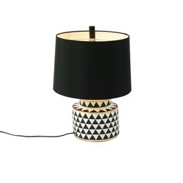 Black and white geometric patterned ceramic base table lamp with black drum shade, modern design.
