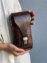 Genuine leather crossbody bag in black and brown colors, made from first layer cowhide leather, with a rectangular shape and a metal hardware detail.
