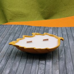 Heidi Bergamot Scented Candle - a round, tall candle with a leaf-shaped design in orange and yellow colors, made of wax material.