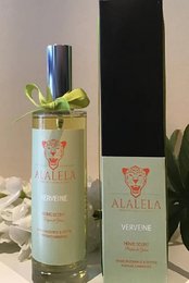 A room spray with a fresh, herbal verbena scent, packaged in a glass bottle with a green ribbon and leaf accent.