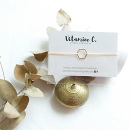 Powder pink charm bracelet with gold-tone metal charm and card.