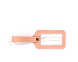  A pink luggage tag with a window for displaying travel information. The tag is made of a durable material and has a sturdy strap for attaching to luggage.