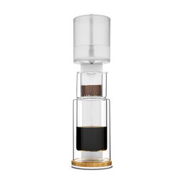 A tall, cylindrical glass cold brew coffee maker with a clear glass carafe and a black base.