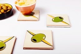 Olive-shaped coasters in a modern, minimalist design. Made of ceramic material with a glossy finish. Suitable for use as drink coasters or decorative accents.