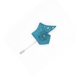 Dark teal pinwheel brooch with decorative cutouts.