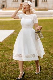  White lace embroidered dress with short sleeves, knee-length, A-line silhouette, suitable for formal or casual occasions.