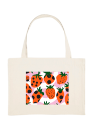 A white tote bag with a vibrant pattern of strawberries, pineapples, and other tropical fruits. The bag has a simple, minimalist design that would be suitable for everyday use or as a reusable shopping bag.