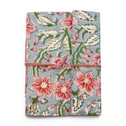  Notebook covered with violet printed fabric featuring floral patterns and designs.

The notebook is covered in a violet-colored printed fabric with a floral pattern. The design includes stylized flowers and leaves in shades of purple, blue, and pink. The fabric has a textured, embroidered-like appearance, adding visual interest to the notebook cover.