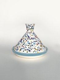 Colorful ceramic pot with floral pattern, suitable for cooking and serving. Includes vegetables and herbs.