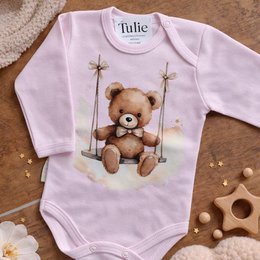 Pink baby bodysuit with teddy bear on swing, long sleeves, cute animal design.