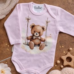 Pink baby bodysuit with teddy bear on swing, long sleeves, cute animal design.
