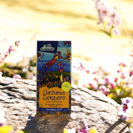 Organic herbal tea with ginger and turmeric, featuring a vibrant package design with a tropical bird and floral elements.