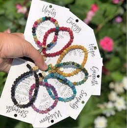 Colorful beaded bracelet with assorted charms in the shape of a butterfly. Made using the traditional Kantha embroidery technique.