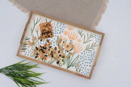 Rectangular wooden serving tray with floral pattern featuring orange and white flowers, leaves, and geometric designs.