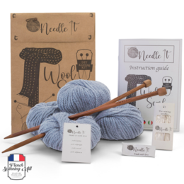 Sky blue knitting kit with needles, wool, and instructions for a beginner to create a scarf. Includes all necessary materials for a knitting project.