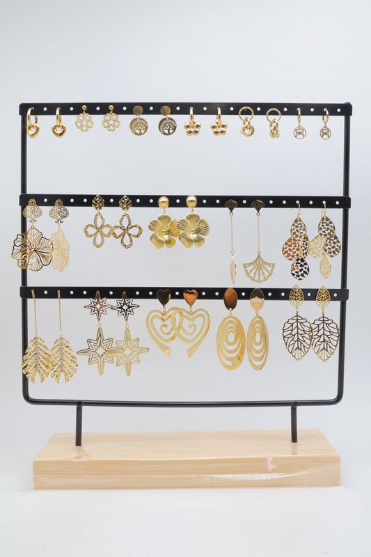 Lot de 16 paires de boucles d'oreilles assorties en acier inoxydable, présentées sur un présentoir métallique avec socle en bois.