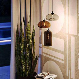 Elegant glass pendant luminaire with adjustable up and low lighting options in clear, amber, and smoke finishes.