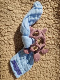 A soft, purple and blue teething ring for babies, designed to soothe gums during the teething process.