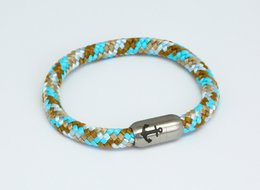 Colorful braided bracelet with anchor charm, made of sailing rope in turquoise, brown, and blue tones.