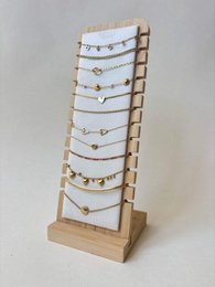 Wooden jewelry display stand with multiple tiers, delicate gold and silver chain necklaces, elegant organizer.
