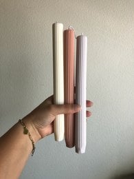 Tall, cylindrical ribbed dinner candles available in pink, lavender, white, olive, and grey colors.