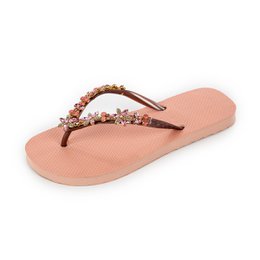 Beige slip-on slippers with embellished straps. Comfortable and stylish footwear for casual wear.