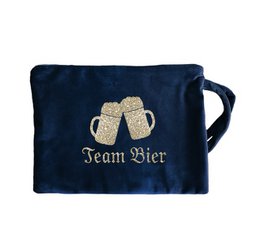 Dark green and navy velvet cosmetic bag with "Happy Holidays" gold text, star design, and red tassel handle.