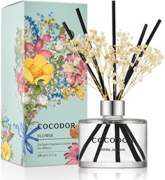 Reed diffuser with real stabilized flowers in various scents and sizes, including 200ml Black Cherry (red flowers), 200ml Pure Cotton (blue flowers), 200ml Rose Perfume (pink flowers), 200ml Garden Lavender (purple flowers), 120ml Black Cherry (red flowers), 120ml Pure Cotton (blue flowers), 120ml Rose Perfume (pink flowers), 120ml Garden Lavender (purple flowers), 200ml White Musk (white flowers), and 200ml Vanilla & Sandalwood (yellow flowers).