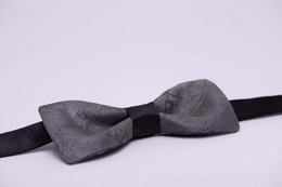 A formal black bow tie with a sleek, modern design. Made of high-quality materials for a sophisticated look.
