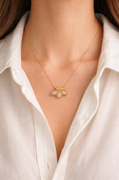 Gold charm pendant necklace with three interlocking rings, delicate minimalist jewelry design.