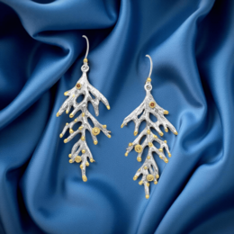  Elegant silver earrings with orange and red sapphires in a branch-like design, perfect for formal or casual wear.