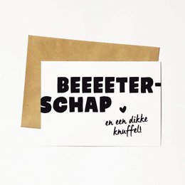 A greeting card with the text "BEEEEETER-SCHAP en een dikke knuffel" (which translates to "BEEEEETER-SHIP and a big hug"). The card is made of white paper with black text and a heart symbol.