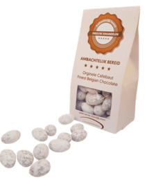 Chocolate-covered almonds in a white package with a brown label. The almonds are round, light-colored, and appear to be coated in a chocolate or sugar glaze.