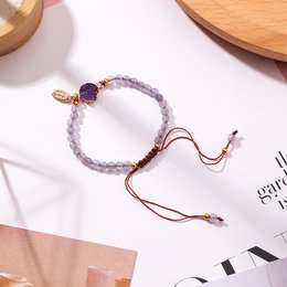 Bracelet with purple moonstone charm, adjustable cord, and gold-tone metal accent.