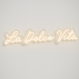 Decorative neon wall light with the text "La Dolce Vita" in a stylized script font. The light has a warm, ambient glow and is suitable for use in a variety of interior design settings.