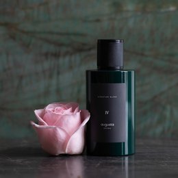 Signature Blend IV perfume by Augusta Aroma. Elegant green glass bottle with a pink rose. Floral, woody, and aromatic scent.