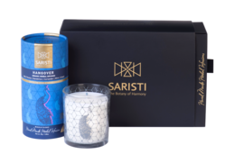 Organic herbal tea blend and assorted natural candle in a gift set. Includes a round, tall white candle with a hexagonal pattern.