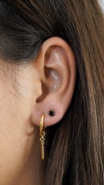 Gold-toned pendant earrings with a zircon stone, featuring a slim, elongated shape for a minimalist, elegant look.