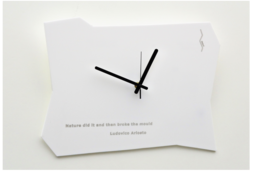A large, white wall clock with a simple, minimalist design. The clock face is plain white with black hands, and the clock is mounted on a white background.