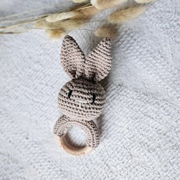  Handmade crocheted rattle rabbit in a neutral sand color, with a textured crochet pattern and a ring for grasping.
