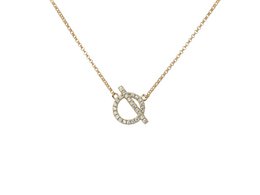 Gold-tone choker necklace with toggle clasp and chain extender for adjustable fit.
