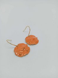 Orange enamel drop earrings with a round, flat shape.