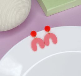 Bright red strawberry-colored statement earrings with a bold arch shape and red bead accents.