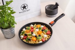 Black non-stick frying pan with wooden handle and red accents. Suitable for cooking various dishes.
