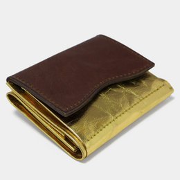A modern, minimalist wallet in a gold and brown color scheme. The wallet features a sleek, rectangular shape with a textured gold exterior and a smooth brown leather interior. This versatile accessory is perfect for everyday use.