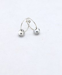 Handmade silver mini hoop earrings with copper star accents. Circular hoop shape, silver-toned metal, small copper star details.