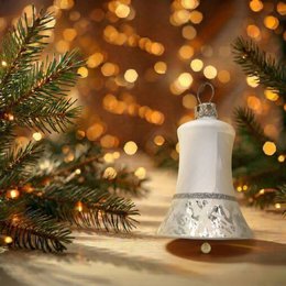 White glass bell-shaped Christmas tree ornaments with a snowy, icy design.